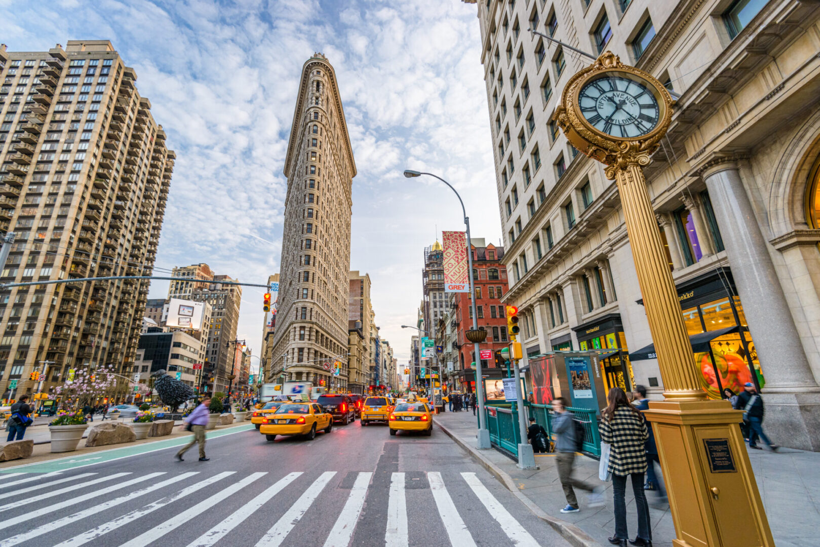 New York, New York, USA - April 15, 2013: Pedestrians stroll below the Flatiron Building. Finished in 1902, the landmark skyscraper was designated a City Landmark in 1966 and a National Historic Landmark in 1989.